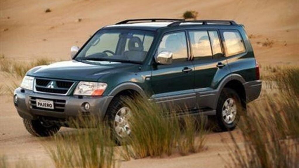 Mitsubishi Pajero 2004 verde parado na diagonal.