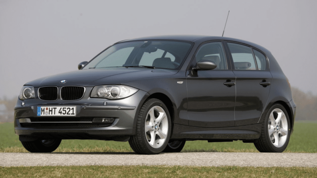 BMW 130i 2009 cinza parado na diagonal.