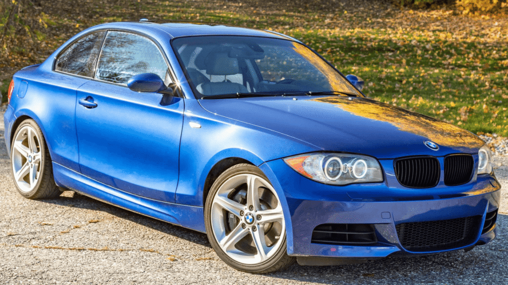 BMW 135iA 2009 azul parada na diagonal.