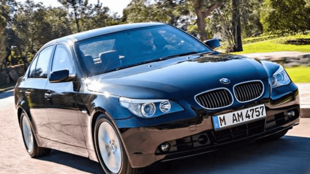 BMW 545iA 2006 preto em movimento na estrada.