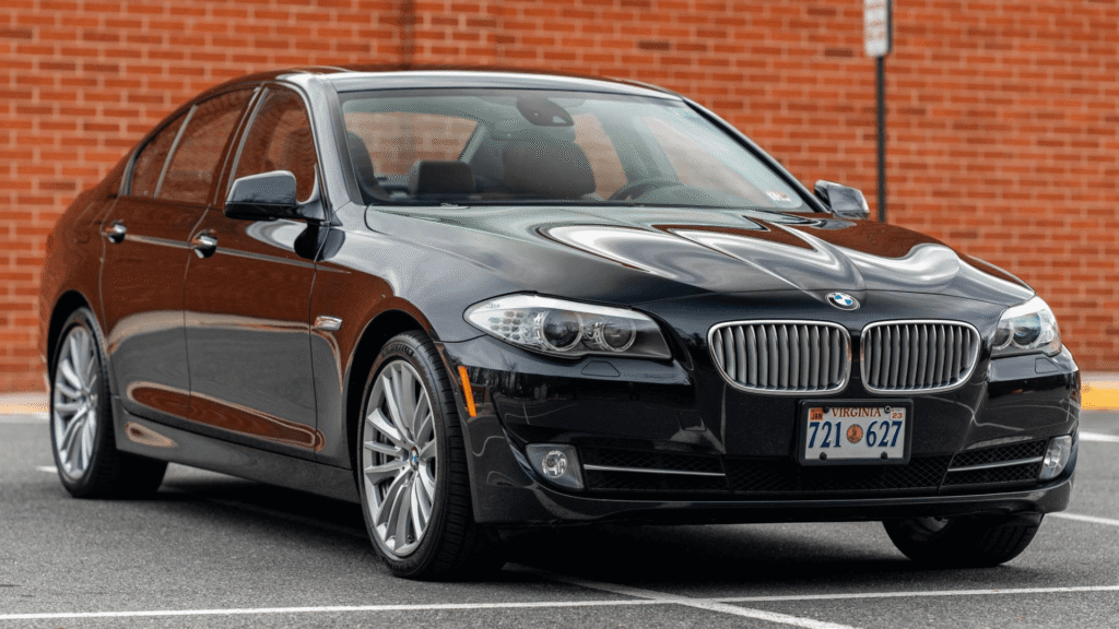 BMW 550iA 2011 preto parado na diagonal.
