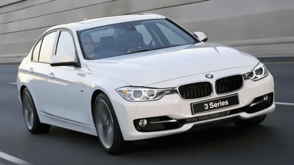 BMW 316i 2015 branca em movimento na estrada.