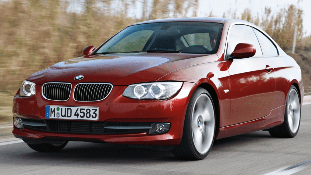 BMW 318iA 2012 vermelha em movimento na estrada.