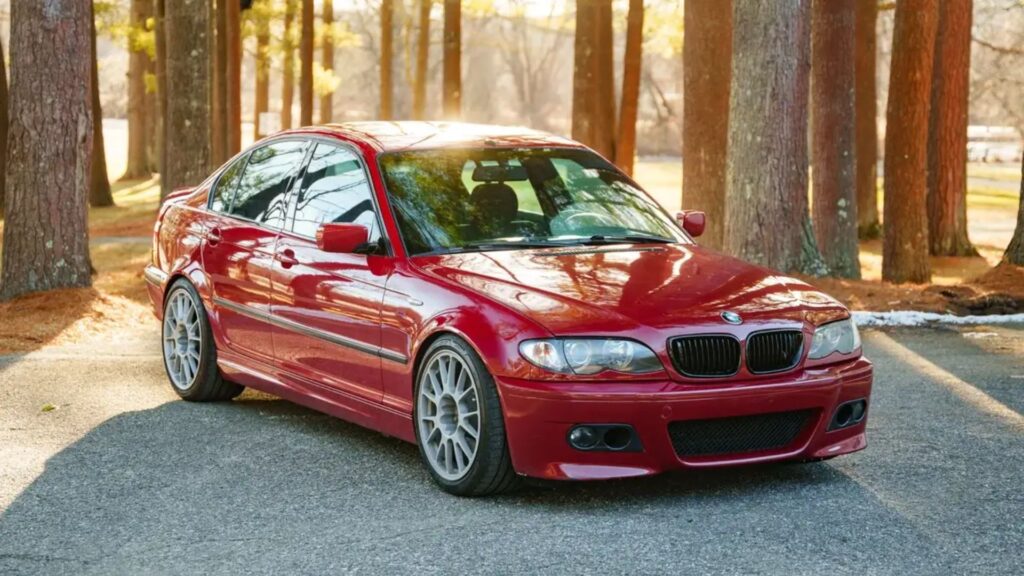BMW 330i 2003 vermelho parado na diagonal.