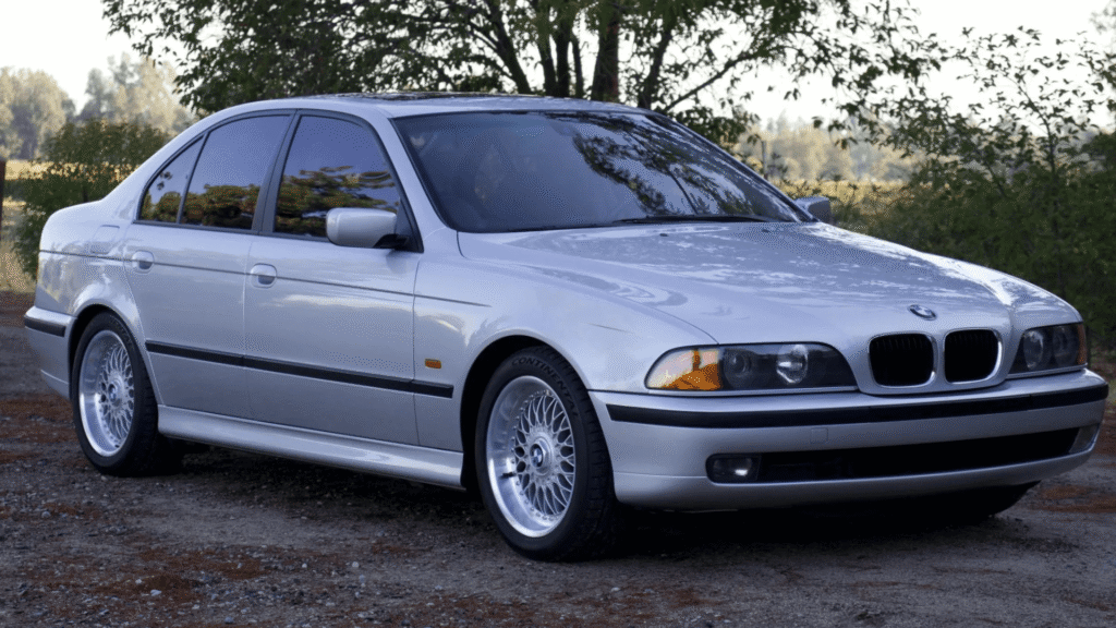 BMW 528i/iA 2000 cinza parado na diagonal.