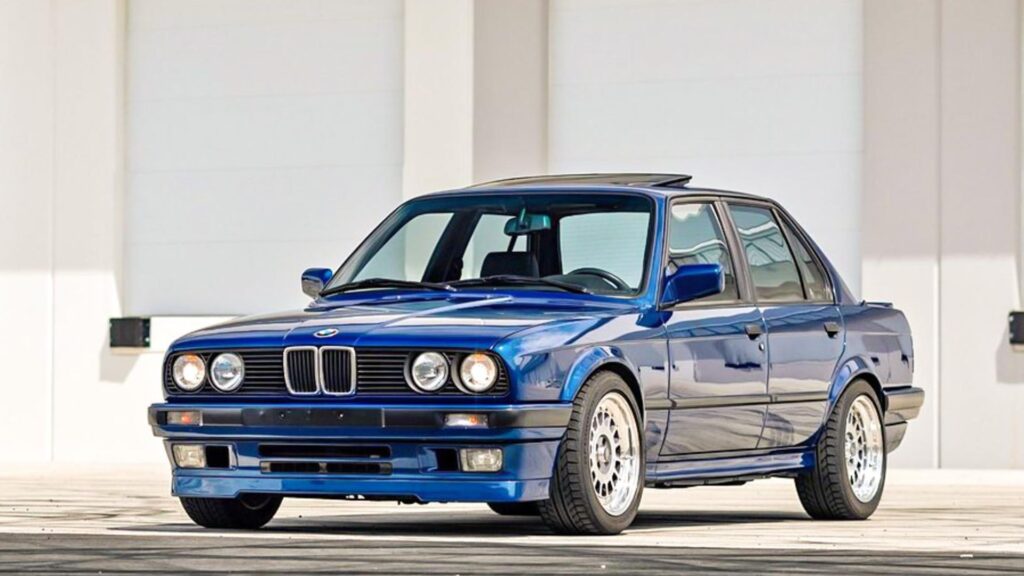 BMW 325i 1989 azul parado na diagonal.