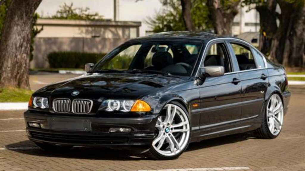 BMW 325i 1997 preto parado na diagonal.