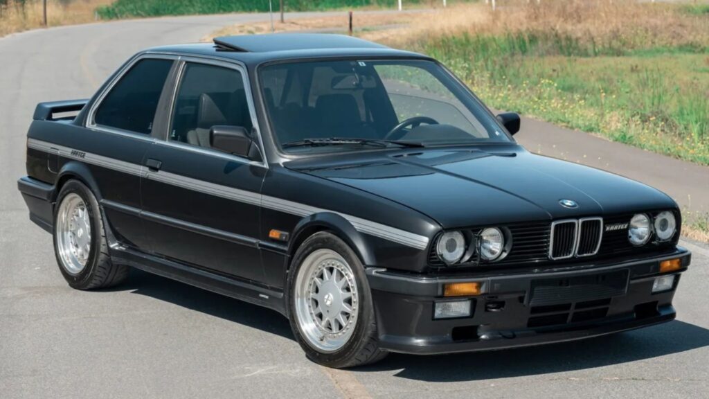 BMW 325i 1986 preto parado na diagonal.